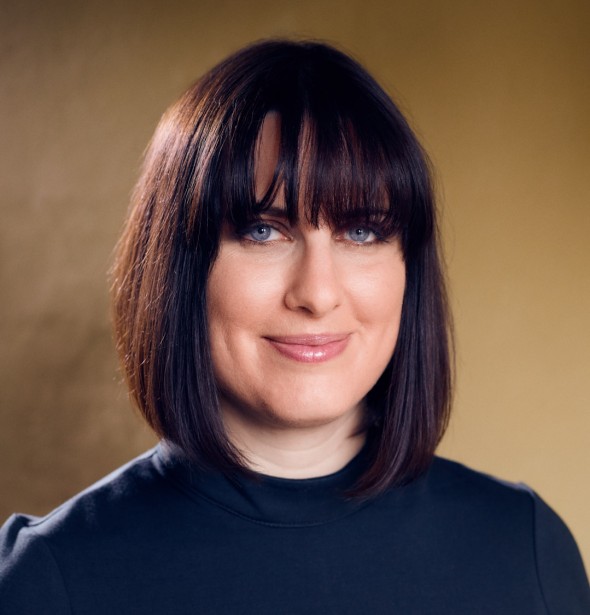 A headshot of Abigail with a beige background